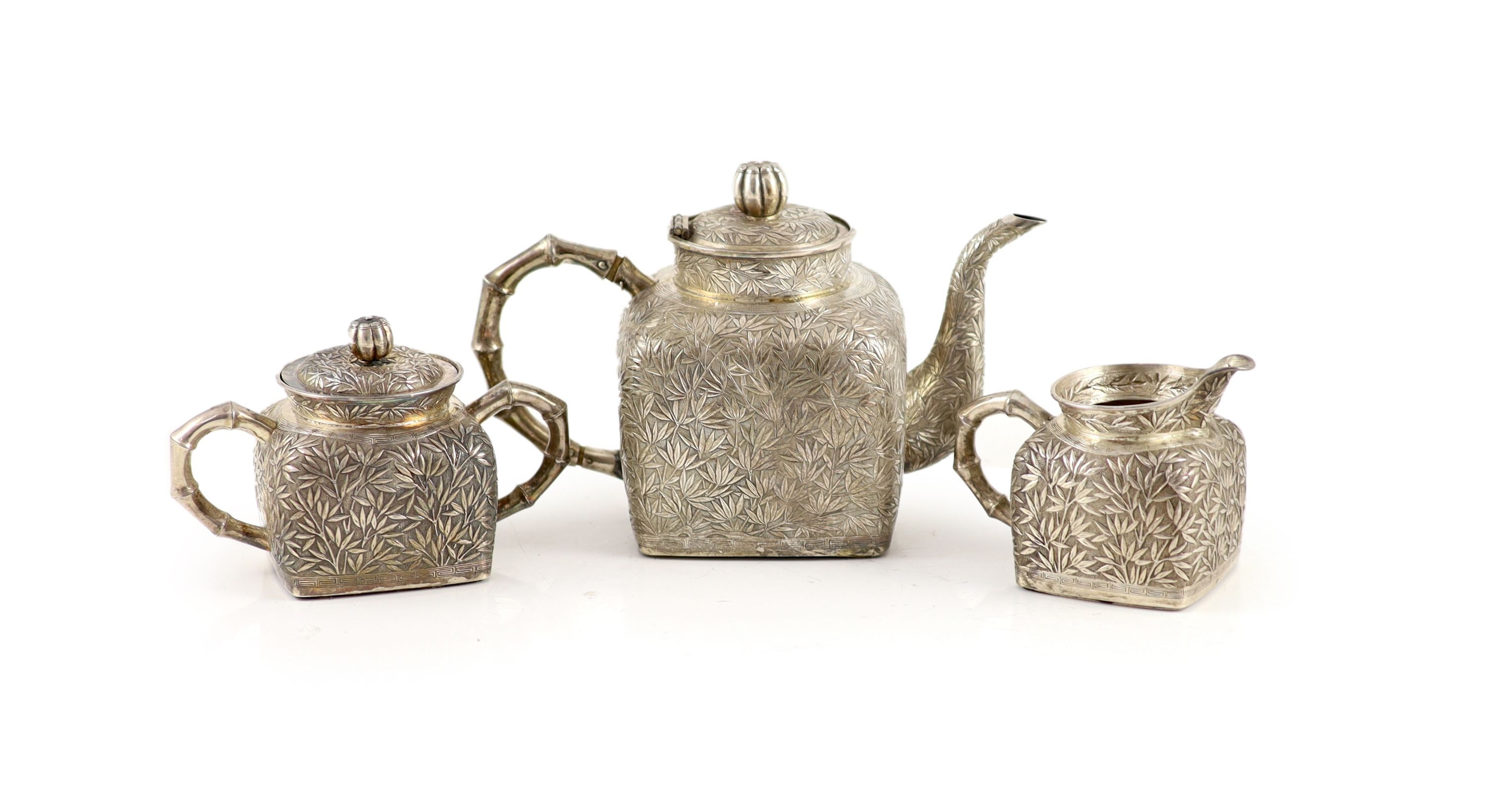 A late 19th/early 20th century Chinese Export silver three piece tea set (a.f.)
